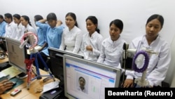 Para pekerja migran tujuan negara-negara Timur Tengah difoto untuk pembuatan paspor di kantor imigrasi Tangerang, Banten, 23 Juni 2011. (Foto: REUTERS/Beawiharta)