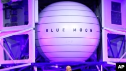 FILE - Jeff Bezos speaks in front of a model of Blue Origin's Blue Moon lunar lander, May 9, 2019, in Washington.