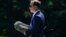 FILE - Jordan Karem, right, Deputy Assistant to the President and Director of Oval Office Operations, carries newspapers as he walks across the South Lawn of the White House in Washington, Aug. 24, 2018.