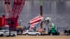 Una grúa descarga una pieza del avión de American Airlines que chocó con un helicóptero Black Hawk cerca del Aeropuerto Nacional Ronald Reagan de Washington, el miércoles 5 de febrero de 2025, en Arlington, Virginia. 