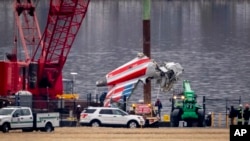 Una grúa descarga una pieza del avión de American Airlines que chocó con un helicóptero Black Hawk cerca del Aeropuerto Nacional Ronald Reagan de Washington, el miércoles 5 de febrero de 2025, en Arlington, Virginia. 