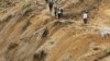 Residents walk along a path in an area affected by a landslide after an earthquake struck in Koto Timur district in Padang Pariaman, a port city sits atop one of the world's most active seismic fault lines along the Pacific ‘Ring of Fire’, Oct. 3, 2009