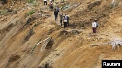 Warga berjalan di jalan setapak di wilayah yang terkena bencana tanah longor di Koto Timur,Padang Pariaman (Foto: dok). Dua buah insiden tanah longsor dilaporkan terjadi di wilayah Sumatera, menewaskan sedikitnya sembilan orang dan 17 orang dinyatakan hilang (26/1).