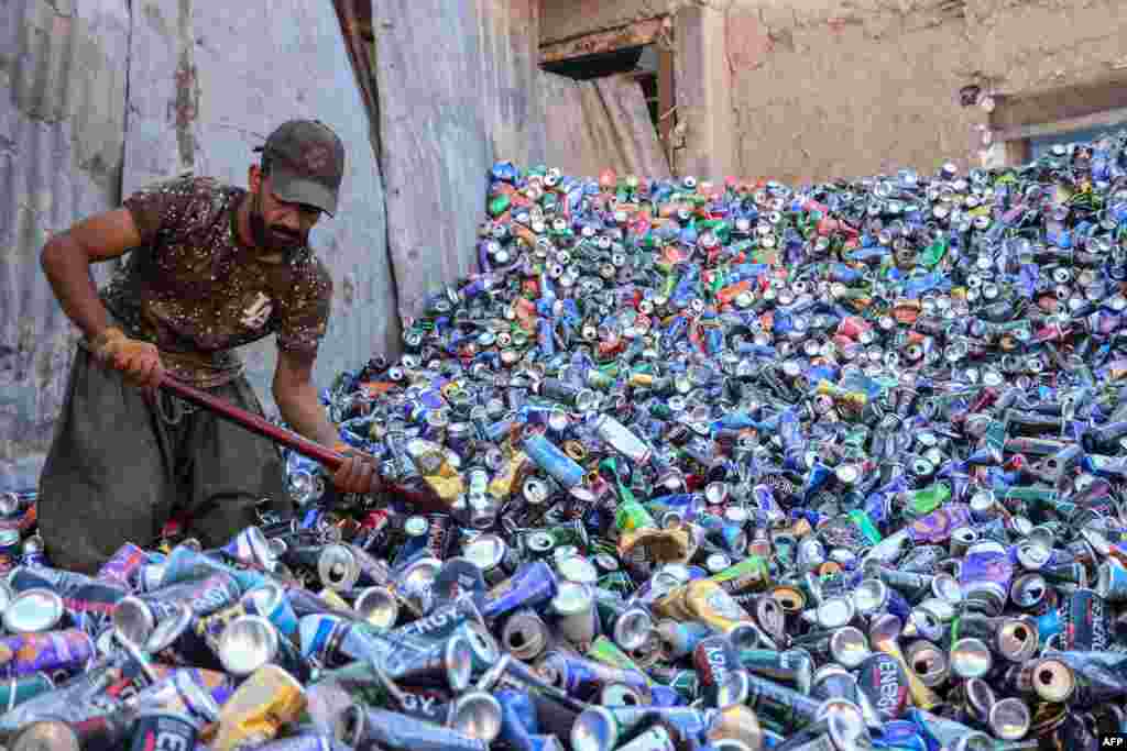 An Afghan worker sorts used aluminum cans at a recycling yard in Herat.