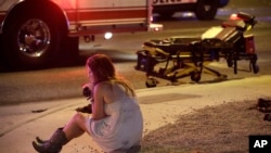 FILE - In this Oct. 2, 2017, file photo, a woman sits on a curb at the scene of a shooting outside of a music festival along the Las Vegas Strip. Months after Facebook and Google announced major efforts to curb the spread of false stories masquerading as news, it’s still cropping up, most recently in the wake of the Las Vegas mass shooting. 