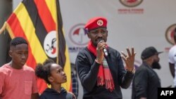 Le musicien ougandais Robert Kyagulanyi, ou Bobi Wine, prononce un discours avec sa fille Suubi et son fils Shadrack Mbogo au siège de son parti NUP, à Kampala, le 26 janvier 2024. 