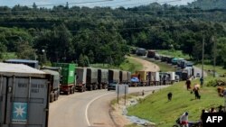 FILE - Trucks wait in a line on the road to enter Uganda in Malaba, a city bordering with Uganda, western Kenya, April 29, 2020. (AFP)