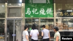 The Arabic script on the signboard of a halal food store is seen covered, at Niujie area in Beijing, China, July 19, 2019.REUTERS