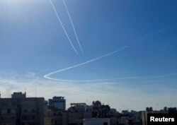 Avioni ostavljaju tragove kondenzovane pare na nebu iznad Bejruta, Liban, 10. decembra 2023.