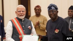 Waziri mkuu wa India Narendra Modi (kushoto) akishika hati ya medali kuu ya heshima ya Nigeria Grand Commander of the Order of the Niger (GCON) aliyokabidhiwa na rais Bola Tinubu(kushoto) hapo Novemba 17, 2024.