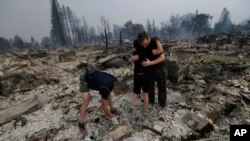Una familia busca entre los escombros de su vivienda destruida por las llamas en Santa Rosa, California.