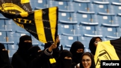 FILE - Saudi women watch a soccer match at King Fahd Stadium in Riyadh, Saudi Arabia, Jan. 13, 2018.