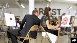 Catherine, Duchess of Cambridge smiles as her husband Britain's Prince William comments on her artistic skills during a visit to the Inner City Arts campus in Los Angeles, July 10, 2011