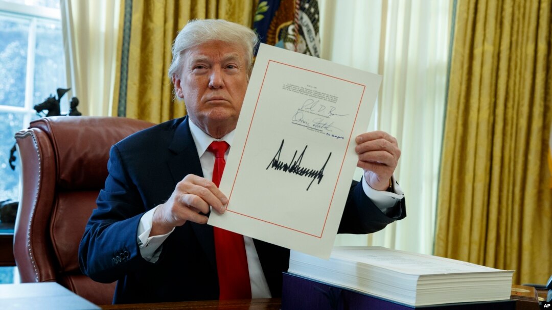 Tổng thống Donald Trump trưng ra dự luật thuế vừa được ông ký ban hành trong Phòng Bầu dục, Nhà Trắng, ở Washington, ngày 22 tháng 12, 2017.