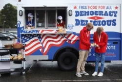 FILE - Young people are joining the efforts to deliver free food and drink to voters waiting in long lines at the polls, October 29, 2020, in Charlotte, N.C. (Travis Dove/AP Images for Pizza to the Polls)