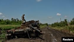 Ukrajinski vojnik pregleda uništeni ruski tenk u nedavno oslobođenom selu Novodarivka