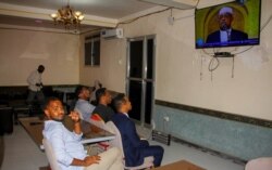 FILE - People watch news about the coming election on a television in Mogadishu, Somalia, Jan. 28, 2021. As Somalia marks three decades since a dictator fell and chaos engulfed the country, the government is set to hold a troubled national election.