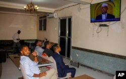 FILE - People watch news about the coming election on a television in Mogadishu, Somalia, Jan. 28, 2021. As Somalia marks three decades since a dictator fell and chaos engulfed the country, the government is set to hold a troubled national election.