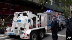 FILE - A police truck tows a total containment vessel to a post office in midtown Manhattan to dispose of a suspicious package, October 26, 2018. Police said a package resembling parcels sent to critics of President Donald Trump had been found at the local postal facility.