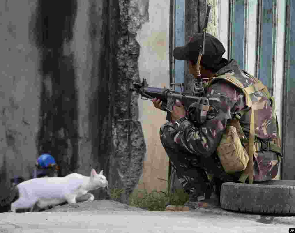 Seorang tentara pemerintah Filipina mengambil posisi, sementara sekitar 200 gerilyawan Muslim yang marah oleh pelanggaran kesepakatan damai, menyandera warga sipil di Filipina selatan.