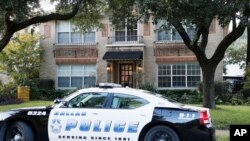 Un auto de la policía vigila la entrada a la residencia de la enfermera que dio positivo por ébola en Dallas.