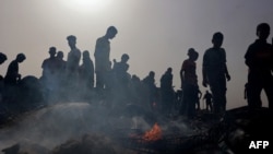 Palestinci se okupljaju na mestu izraelskog udara na kamp interno raseljenih ljudi u Rafi, 27. maja 2024.