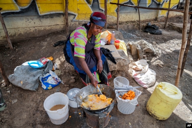 A woman fries potatoes in the low-income Kibera neighborhood of Nairobi, Kenya, Tuesday, April 19, 2022. (AP Photo/Khalil Senosi)