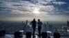 Two men enjoy the city skyline view on the 314-meter high rooftop terrace of the Mahanakhon building in Bangkok on Nov. 11, 2020.