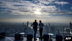 Two men enjoy the city skyline view on the 314-meter high rooftop terrace of the Mahanakhon building in Bangkok on Nov. 11, 2020.