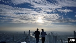 Two men enjoy the city skyline view on the 314-meter high rooftop terrace of the Mahanakhon building in Bangkok on Nov. 11, 2020.