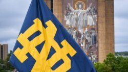 FILE - A Notre Dame monogram flag waves in front of the Word of Life mural on the campus of the University of Notre Dame, in South Bend, Indiana, Sept. 28, 2019.
