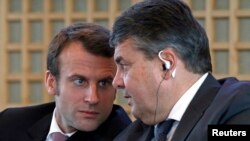 French Economy Minister Emmanuel Macron (L) and Germany's Economy Minister Sigmar Gabriel attend a news conference to present the Franco-German report on economic reforms and investment at the Bercy Finance Ministry in Paris, Nov. 27, 2014.