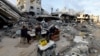 Palestinians sit near the ruins of a house destroyed in the Israeli military offensive in Khan Younis in the southern Gaza Strip, Nov. 29, 2024.