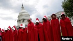 واشنگٹن میں خواتین ایک فلمی کردار ہینڈ میڈز کے کاسٹیوم میں ری پبلیکن پارٹی کی ہیلتھ کیئر تجاویز کے خلاف مظاہرہ کر رہی ہیں۔ 17 جون 2017