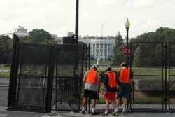 Workers remove a security fence, June 10, 2020, near the White House in Washington.