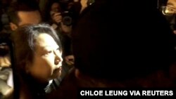Hong Kong Justice Secretary Teresa Cheng walks as protesters surround her in London, Nov. 14, 2019, in this still image from video obtained via social media.