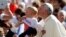 El papa Francisco besa a un niño en la Plaza de San Pedro en el Vaticano.