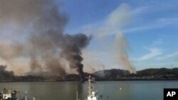 This picture taken by a South Korean tourist shows huge plumes of smoke rising from Yeonpyeong island in the disputed waters of the Yellow Sea on November 23, 2010. North Korea fired dozens of artillery shells onto a South Korean island, setting of an exc