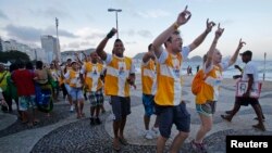 Pelren ki tap danse e chante sou Plaj Copacabana, nan Rio de Janeiro, anvan Pap François vizite vil la. 