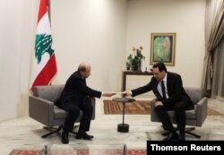 Lebanon's Prime Minister Hassan Diab submits his resignation to Lebanon's President Michel Aoun at the presidential palace in Baabda