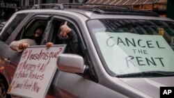 FILE - Protesters with signs calling for rent cancellations drive in a caravan en route to the offices of New York Governor Andrew Cuomo in New York City, May 1, 2020. A moratorium on evictions in the U.S. is due to expire. 