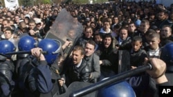 Algerian students scuffle with riot police officers near the Ministry of Higher Education in Algiers, February 21, 2011