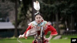 FILE - In this April 4, 2020, photo, Wicahpi Cuny, 14, a Dakota and Lakota tribal member, dances during a livestreamed powwow from a park near her home, in Puyallup, Wash.