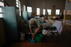 Manuel Dommar, de 89 años, se lava los pies en un dormitorio en La Providencia San Antonio, un hogar para ancianos, en medio de la nueva pandemia de coronavirus, en Caracas, Venezuela, el miércoles 4 de agosto de 2021.