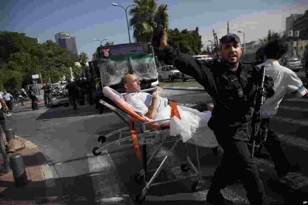 Israeli rescue workers and paramedics carry a wounded person from the site of a bombing in Tel Aviv, Israel, November 21, 2012.