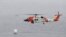 A U.S. Coast Guard helicopter flies over boats searching the area where a boat capsized just off the San Diego coast May 2, 2021, in San Diego, California.