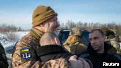 En esta fotografía, publicada y distribuida por el servicio de prensa de la presidencia de Ucrania, se observan prisioneros de guerra ucranianos después de un intercambio con Rusia, el 31 de enero de 2024.