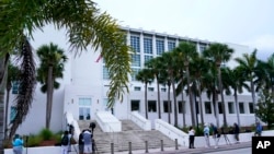 Sejumlah wartawan menunggu persidangan kasus tuduhan penyimpanan dokumen rahasia ilegal terhadap Donald Trump, di luar gedung Pengadilan Alto Lee Adams Sr di Fort Pierce, Florida, 18 Juli 2023. (Foto: Lynne Sladky/AP Photo)