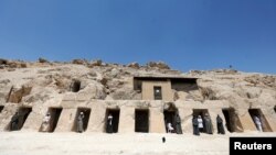 
Para pekerja berdiri di gerbang-gerbang salah satu dari makam "Shedsu Djehuty" yang baru ditemukan di Luxor, Mesir, 18 April 2019. (Foto: REUTERS/Mohamed Abd El Ghany)