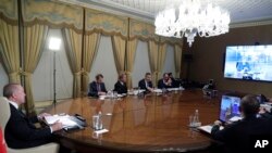 Turkish President Recep Tayyip Erdogan, left, flanked by his ministers and advisors participates in a teleconference with European leaders, in Istanbul, March 17, 2020.